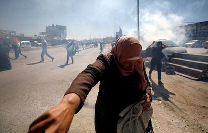 Una mujer palestina reacciona con gas lacrimógeno disparado por las tropas israelíes durante los enfrentamientos en una protesta contra la decisión del presidente estadounidense Donald Trump sobre Jerusalén en la ocupada Cisjordania.