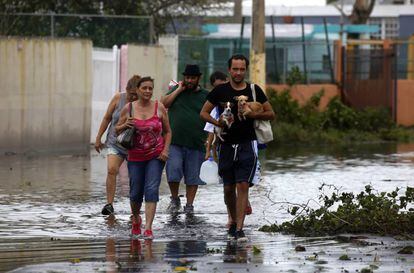 Unas personas caminan por una calle inundada de la isla.