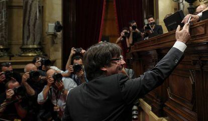 El presidente de la Generalitat, Carles Puigdemont extiene su voto durante la votación en el Parlament sobre la declaración de independencia.