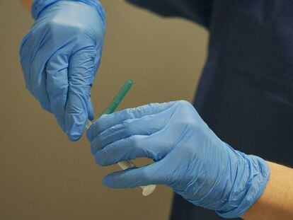 Una trabajadora sanitaria manipula el material necesario para administrar la vacuna contra la COVID-19 en un espacio de Refena, en Pamplona.