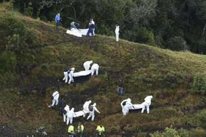 Los equipos de rescate trasladan los cadáveres de las víctimas en una zona montañosa en las afueras de Medellín (Colombia).