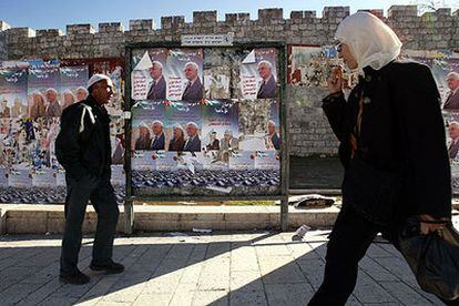 Dos palestinos pasan ante carteles de propaganda electoral en la ciudad vieja de Jerusalén.