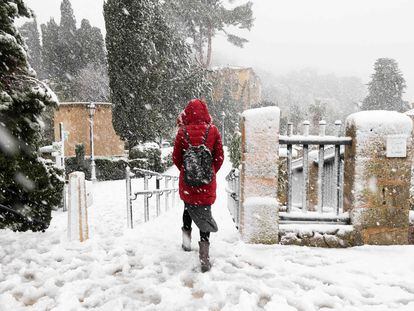 Una persona camina por una calle cubierta de nieve en el pueblo de Valldemossa en la isla de Mallorca.