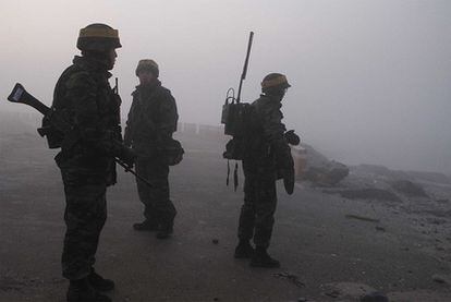 Soldados surcoreanos patrullan la isla de Yeonpyeong a la espera de que comience la jornada de maniobras militares anunciada por Seúl, que ha sido retrasada a causa de la niebla.