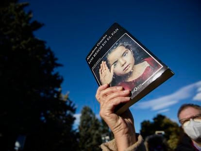 Una persona con un libro en la mano en homenaje a Almudena Grandes, en el entierro de la escritora, el lunes en el Cementerio Civil de Madrid.