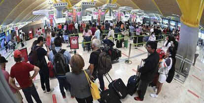 Decenas de personas hacen cola en el Aeropuerto de Barajas de Madrid.