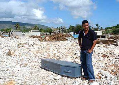 Un hombre espera poder enterrar el cuerpo de un familiar en un cementerio destruido por el alud tras las fuertes lluvias que han azotado la zona de Jimaní, República Dominicana