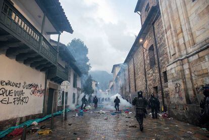 Policías antidisturbios lanzan gases y caminan entre escombros tras las protestas del 21 de noviembre de 2019.