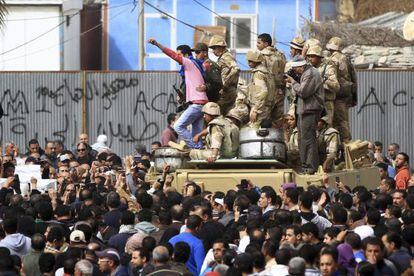 Ciudadanos egipcios rodean un vehículo militar ocupado por unos soldados en Port Said