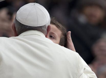 El Papa Francisco besa a un niño a su llegada a la audiencia semanal en la plaza de San Pedro en el Vaticano.