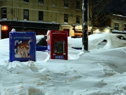 Buzones dispensadores de prensa en 2016 en un Nueva York nevado. A la derecha, el de 'The Village voice'.