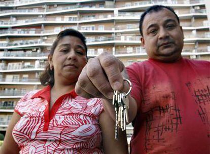El ecuatoriano Marlon Flor y su esposa, Yesenia, entregan simbólicamente las llaves del piso que no pueden pagar.