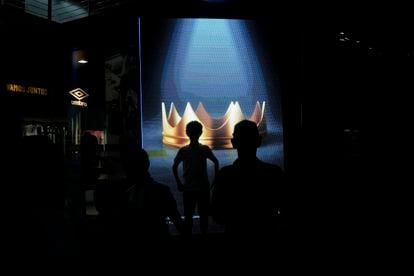 Visitors to the official store at the Santos club stadium, in front of a screen displaying a crown for the "King" of Brazilian soccer.