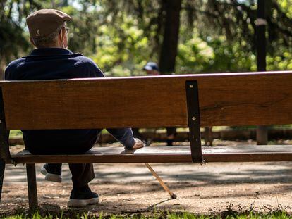 Un hombre mayor sentado en un banco del parque Caramuel, en el barrio de Puerta del Angel, Madrid.