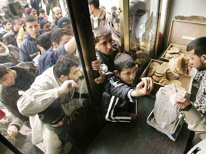 Decenas de palestinos se agolpan en la puerta de una tienda para poder comprar pan, ayer en la ciudad de Gaza.