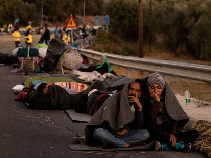 Varias personas pasan la noche al raso en las cercanías del campo de refugiados de Moria.