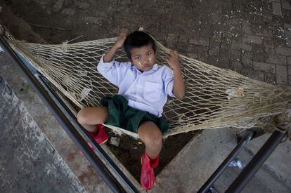 Un niño descansa sobre una hamaca en un embarcadero en Yangon.