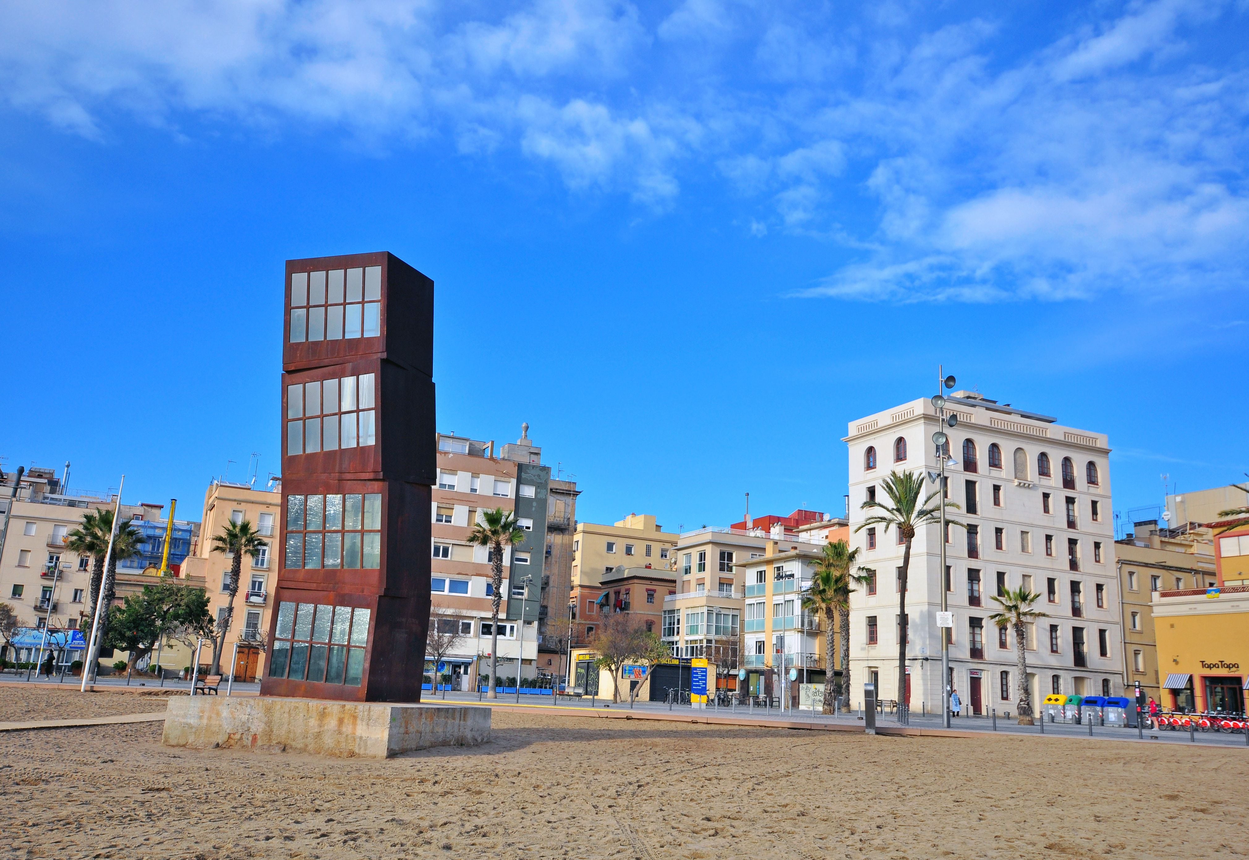 Escultura titulada L'Estel ferit (La estrella herida), de la alemana Rebecca Horn, situada en la playa de la Barceloneta. Al fondo, el barrio del mismo nombre.