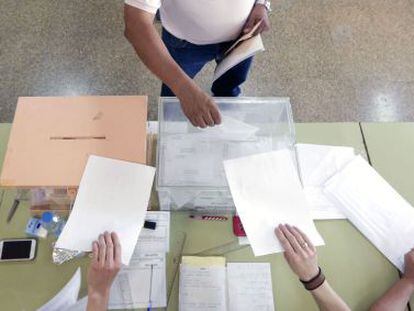 Un hombre deposita su voto en la urna de los diputados