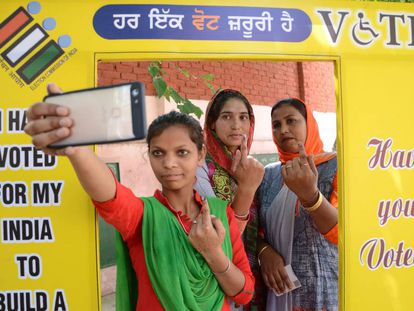 Tres mujeres se fotografían enseñando el dedo manchado de tinta tras votar este domingo en Amritsar.