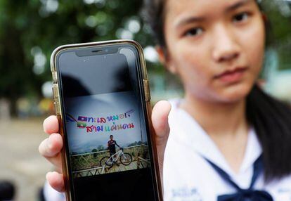 Una estudiante muestra una foto de su compañero Prachak Sutham, uno de los menores encerrados en la cueva de Tham Luang (Tailandia) el pasado lunes.
