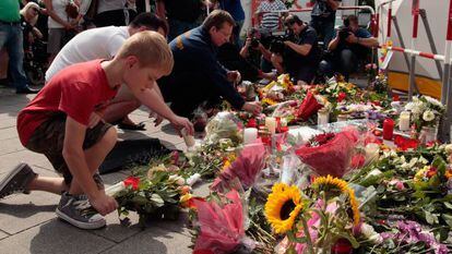 Ciudadanos ponen flores y velas en el exterior del centro comercial donde tuvo lugar el tiroteo.