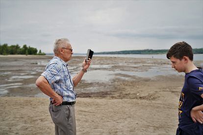 Grigori Markov, de 76 años, visita junto a uno de sus nietos el terreno surgido a orillas del río Dniéper en Zaporiyia tras la bajada del agua debido a la destrucción en junio de la presa de Nova Kajovka.