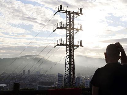 Una persona observa el cableado con el que red eléctrica transporta la energía en Bilbao.