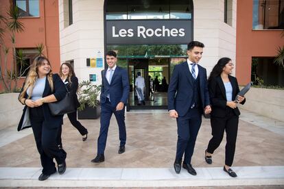 Varios estudiantes salen por la puerta principal de la escuela de negocios Les Roches.