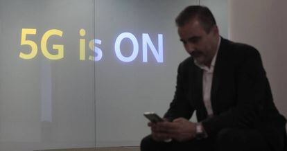 Un hombre, frente a un cartel que anuncia el 5G en la nueva tienda de Huawei en Madrid.