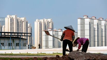 Unos trabajadores delante de unas torres en construcción, en China.
