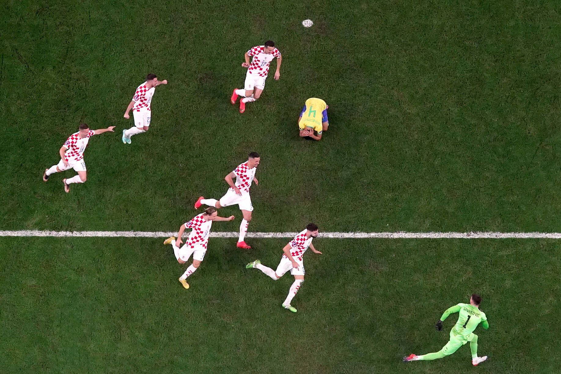 Los jugadores croatas celebran el pase a semifinales, mientras el brasiñelo Marquinhos se lamenta por haber errado en el penalti. 