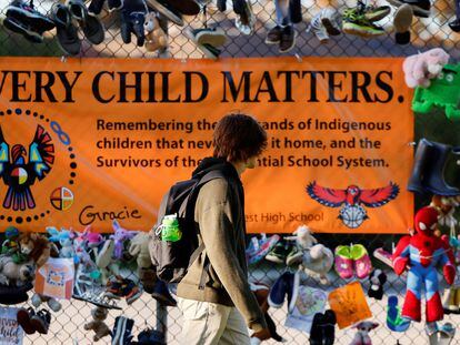 Un estudiante camina delante de un cartel en honor de los niños indígenas que sobrevivieron a los albergues, sus familias y comunidades en Ottawa.