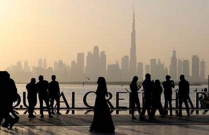 Varias personas contemplan el skyline de Dubái, con la torre Burj Khalifa en el centro.