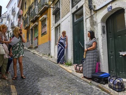 Turistas esperan para entrar en el apartamento que han alquilado en el barrio histórico de Santa Catarina, en Lisboa, el pasado 10 de julio.