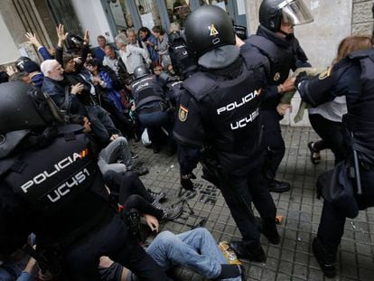 Polic&iacute;as dispersan a un grupo de ciudadanos el 1 de octubre en Barcelona.