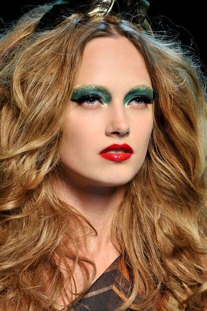 Look sesentero con sombra en tonos verdes, labios vibrantes y cabello con volumen. Es de la colección de otoño-invierno 2011/12 de Dior Haute Couture.
