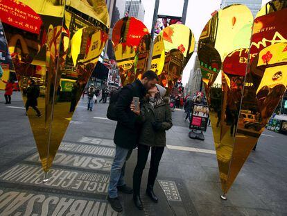 Una pareja se besa entre corazones en Nueva York.