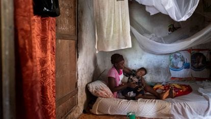 Una adolescente, beneficiaria del proyecto 'Derecho a ser niña', de Save the Children, posa junto a su hijo en su casa del distrito de Pujehun (Sierra Leona).