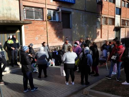 Una familia en el exterior de la vivienda de la que acaban de ser desahuciados, el pasado enero en Barcelona.