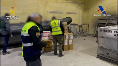Agentes de Vigilancia Aduanera, la Guardia Civil y la policía portuguesa registran la nave donde se preparaban las narcolanchas, en una imagen facilitada por el instituto armado.