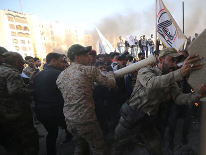 Un grupo de manifestantes intenta romper un cristal blindado de la embajada estadounidense en Bagdad (Irak), el 31 de diciembre.