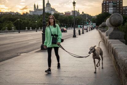 Una mujer pasea con su perro por el puente de Segovia, en Madrid.