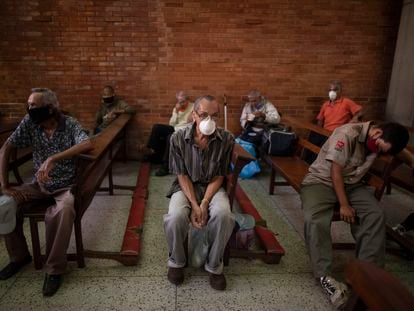 Un grupo de personas espera para recibir alimentos gratuitos en una iglesia de Caracas, Venezuela