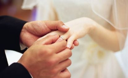 Una pareja intercambia anillos en su boda.