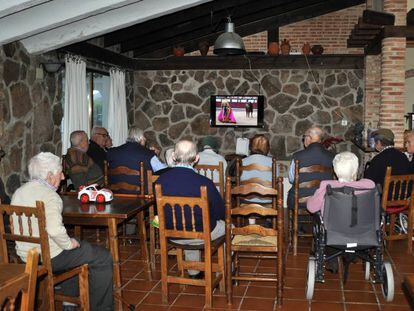 Un grupo de ancianos ven la televisi&oacute;n en una residencia