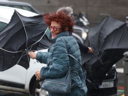 Una mujer se enfrenta a las fuertes rachas de viento, mientras camina por una calle del centro de Madrid este jueves.
