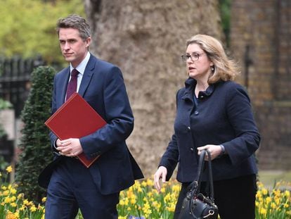 El ministro de Defensa cesado, Gavin Williamson, y su sustituta, Penny Mordaunt, caminan juntos hacia Downing Street.