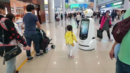 Un robot guía a una familia en un aeropuerto.