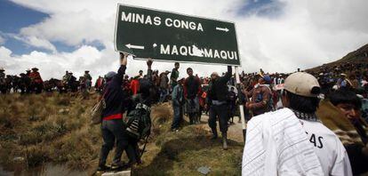 Manifestantes destruyen un cartel de la empresa responsable del proyecto minero en la región peruana de Cajamarca.